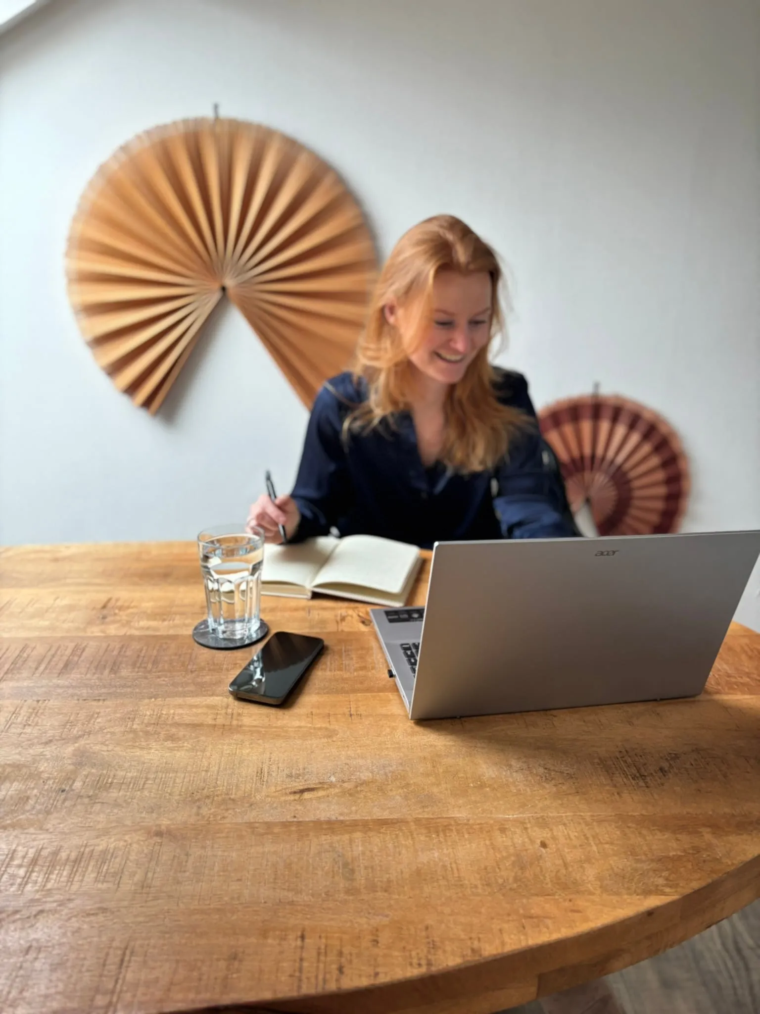 Celine Pranger aan het werk achter haar laptop met een notitieboek