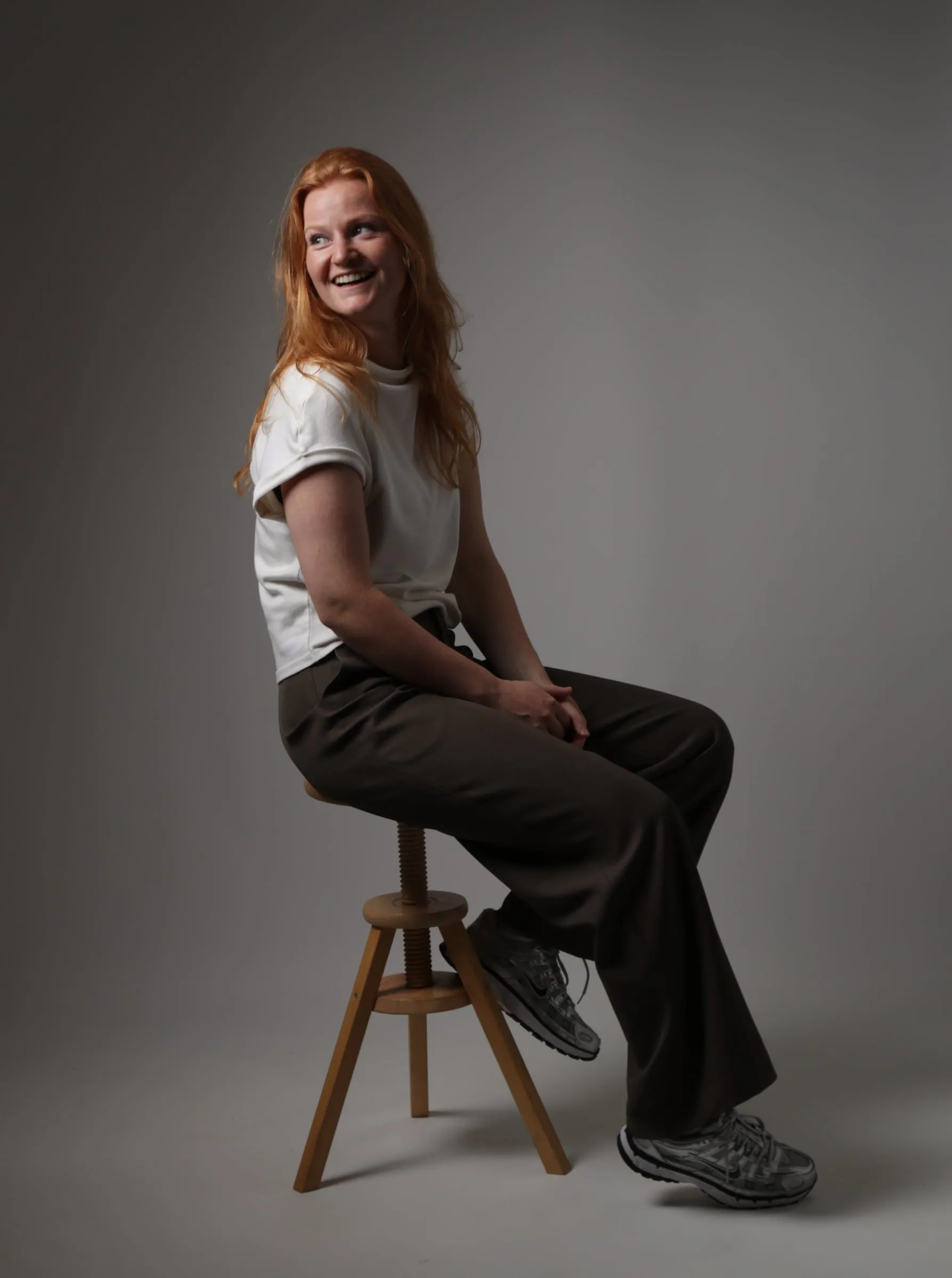 Celine Pranger van Freelanceline, lachend op een houten kruk