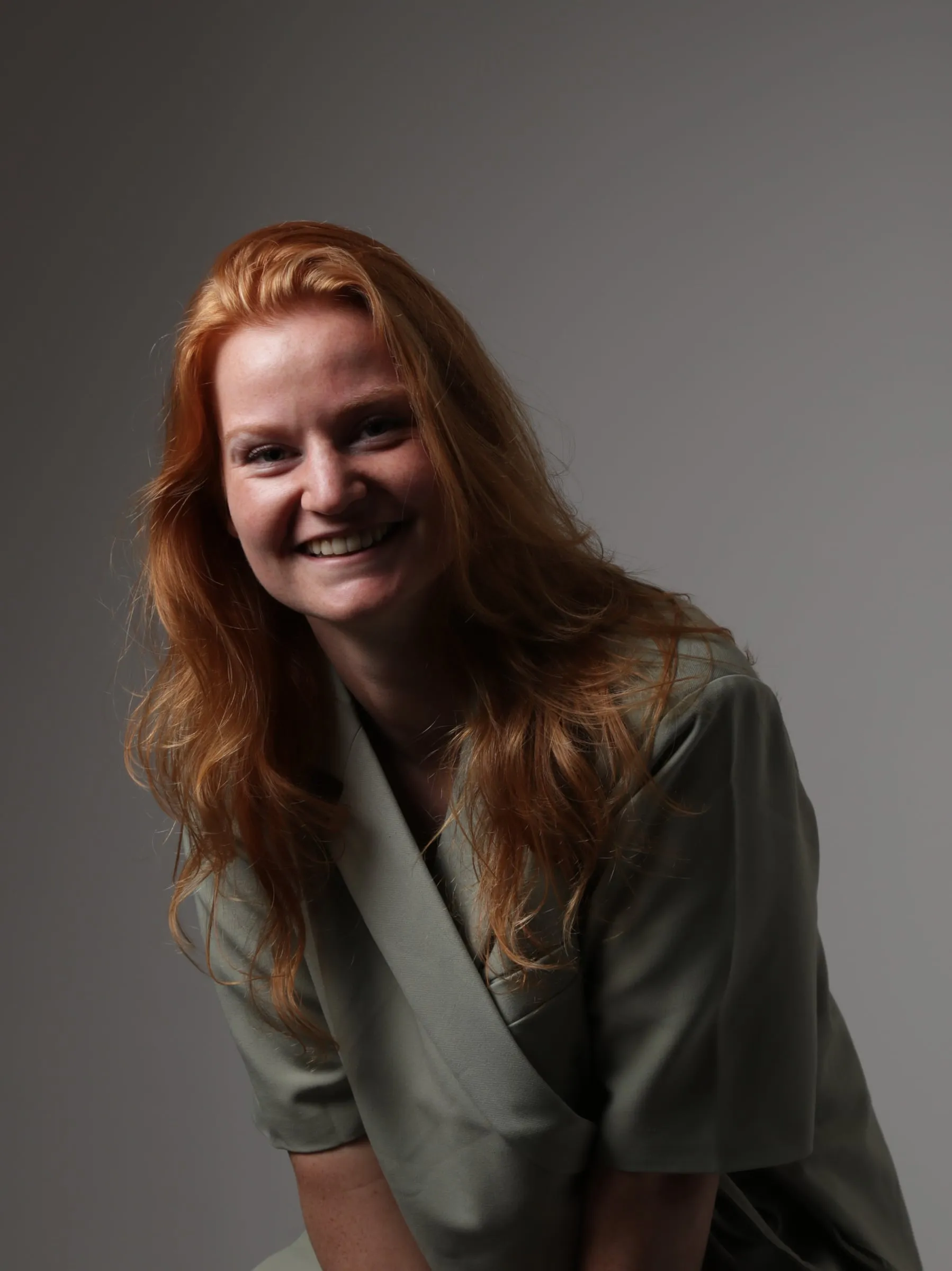 Portret van Celine Pranger, lachend in een groene blazer